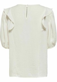 Blouse texturée blanc cassé avec manches bouffantes longueur coude, détails volantés sur les épaules et fermeture au dos par bouton avec ouverture en forme de trou.