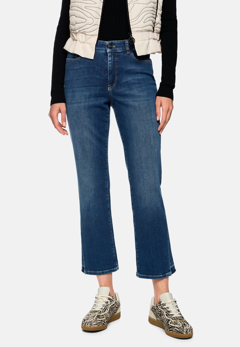 Blaue, verkürzte Schlagjeans aus Denim mit mittlerer Waschung, ausgestattet mit klassischem Fünf-Taschen-Design und leicht ausgefranstem Saum.