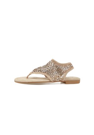 Sandalia plana beige con diseño de tira entre los dedos y parte superior cubierta de brillantes piedras de strass, talón abierto y suela acolchada.