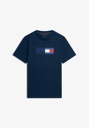 Tumesinine lühikeste varrukatega ümarakaelusega T-särk, millel on Tommy Hilfigeri logo ja punase, valge ning sinise ristkülikukujuline lipp rinnal.