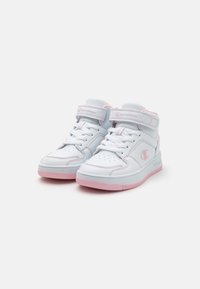 Baskets mid-top blanches avec des accents roses. Fabriquées en matériaux synthétiques, elles présentent une sangle Velcro, un bout perforé et une semelle en caoutchouc texturé.