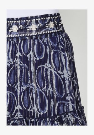 Jūras zilas svārku ar rakstu dizainu, kurā ir gaiši zili viļņi un svītras. Jostasvieta ir rotāta ar izšūtām ziedu akcentiem.