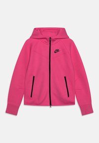 Růžová mikina na zip s kapucí, černým zipem a černým logem Nike na hrudi. Obsahuje dvě přední kapsy na zip a žebrované manžety.