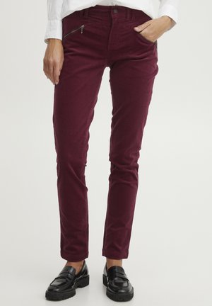 Burgundy kordflorsbyxor med slim fit, med fickor fram med dragkedja och robust sömnad, i kombination med svarta loafers.