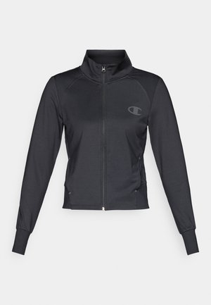 Chaqueta deportiva negra con cremallera en la parte delantera, cuello alto, mangas largas y detalles acanalados en los hombros. Presenta un logo en el pecho.