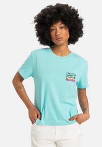 Turquoise cotton t-shirt with a round neck and short sleeves. Features a graphic pocket print of palm trees and sunset in vibrant colors.