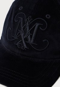 Mørk marineblå kordfløyels baseballcap med broderte overlappende bokstaver N, & og K i matchende tråd på frontpanelet.