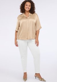 Satin beige shirt met korte mouwen en een kraag, gecombineerd met witte slim-fit broek en slangenprint hakken. Soepele textuur en relaxte pasvorm.