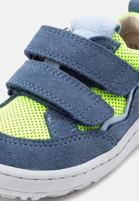 Παιδικό αθλητικό παπούτσι σε ναυτικό μπλε και νέον πράσινο, με διπλά λουράκια με αγκράφα και λευκή σόλα.