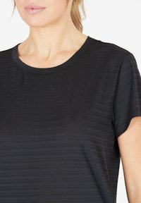 Sort tekstureret t-shirt med rund halsudskæring, korte ærmer og diskrete vandrette striber på et glat stof.