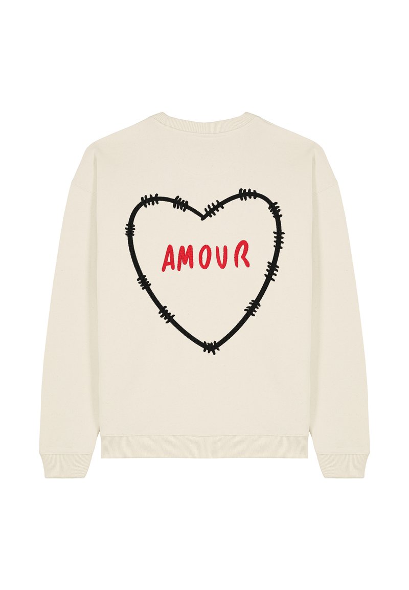 Sweatshirt de couleur crème avec un grand cœur en contour noir et le mot "AMOUR" en rouge, positionné de manière proéminente au dos.