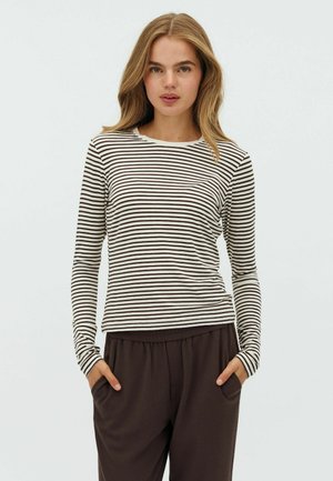 Long-sleeve top in cream with dark brown horizontal stripes, featuring a round neck and slim fit design, paired with brown relaxed-fit pants.
