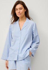 Gestreept blauw pyjama-set met lange mouwen, een knoopsluiting, een borstzak en bijpassende korte broek. Licht, ademend materiaal met een ontspannen pasvorm.