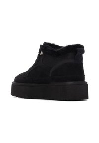 Botas negras hasta el tobillo con un empeine de ante texturizado, forro de piel de piel en el cuello y una suela gruesa y robusta; cuenta con un sistema de cordones y una lengüeta.