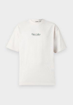 T-shirt blanc à manches courtes avec le texte vert "Parks Gallery Local Creators Collective" centré sur la poitrine, présenté sur un fond uni.