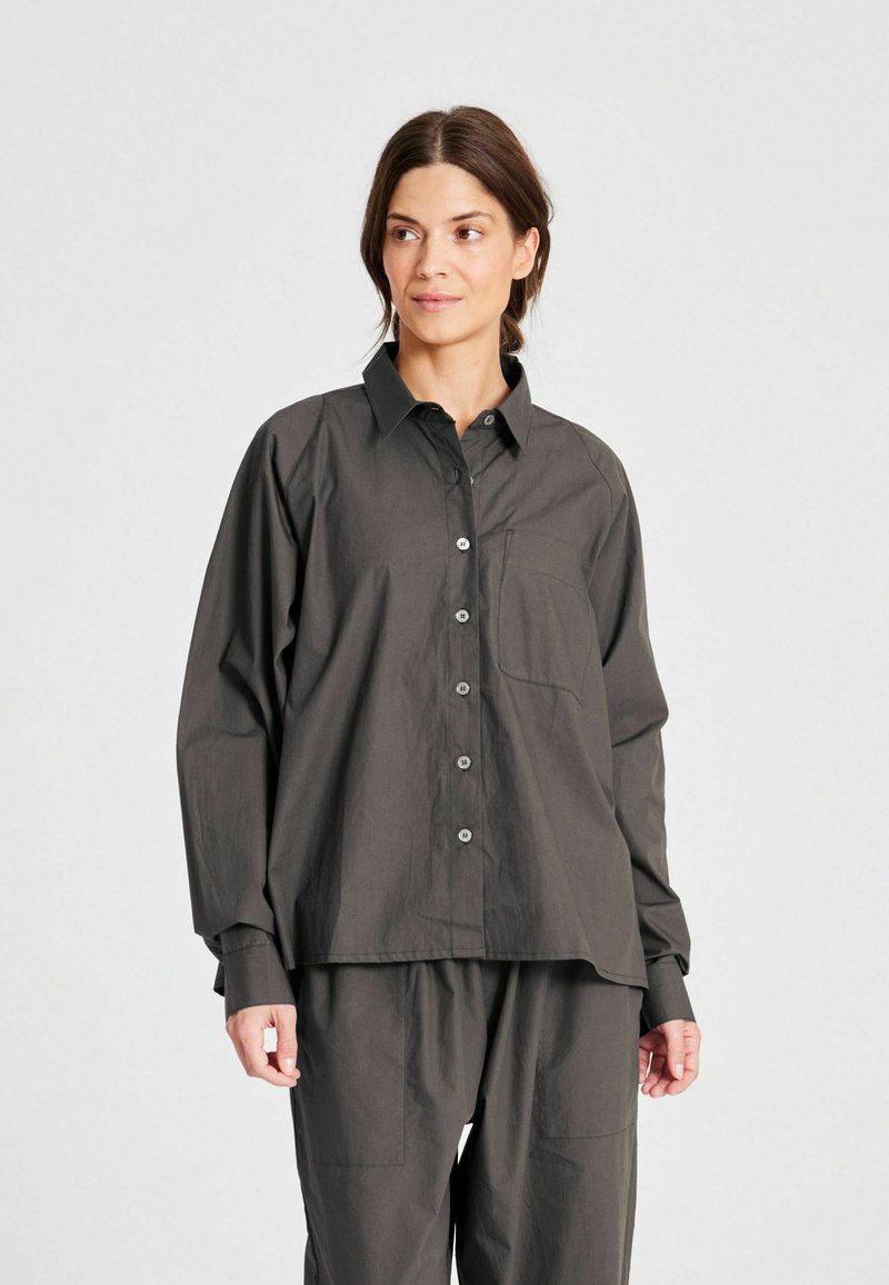 Camicia pulsante grigio scuro con colletto, maniche lunghe e tasca sul petto. Realizzata in un tessuto texturizzato con una vestibilità comoda.