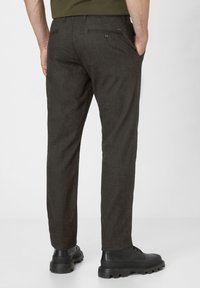 Dark grey tailored trousers with a flat front, two back pockets, and a straight leg fit, paired with black lace-up boots.