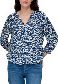 Blauw en wit gebloemde blouse met een v-hals, driekwartmouwen en een losse pasvorm, met een golvend, abstract patroon.