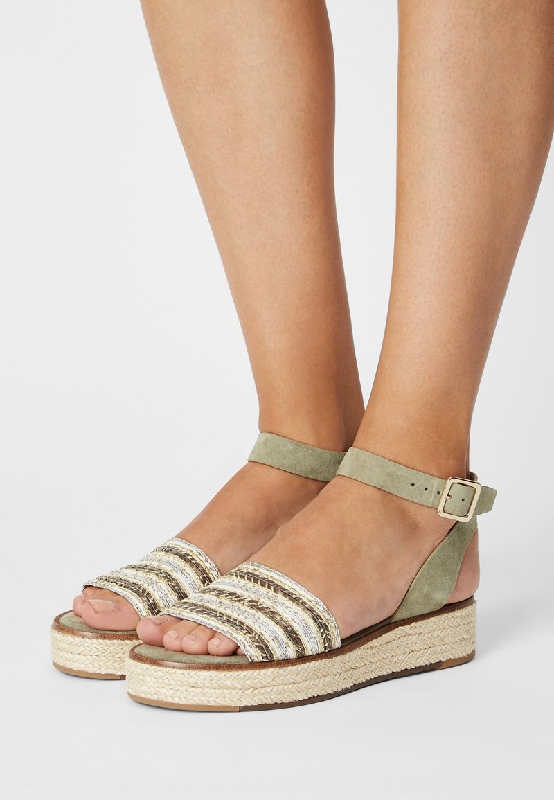 Sandales en suede vert clair avec des brides en jute rayées, plateforme espadrille tressée, bride de cheville ajustable, design à bout ouvert.