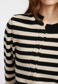 Cardigan lavorato a maglia a strisce nere e beige, con scollatura a girocollo, chiusura a bottoni e texture morbida.