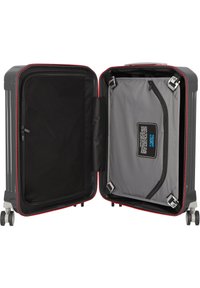 Maleta de mano rígida con un exterior gris y acentos rojos. El interior cuenta con compartimentos con cremallera y un bolsillo de malla para organización.