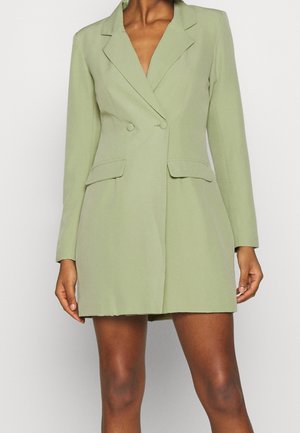 Robe-blazer vert clair avec un col aux revers crantés, des boutons croisés et deux poches avant ; texture lisse avec une coupe ajustée.