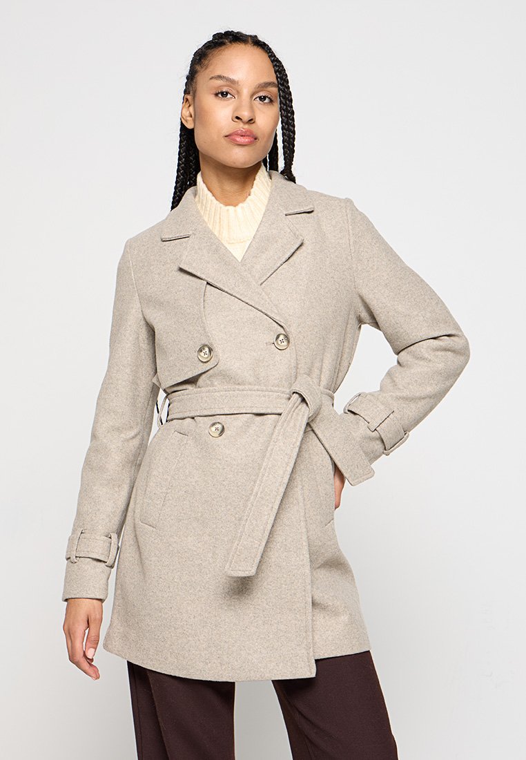 Manteau double boutonnage en mélange de laine beige avec une ceinture, des poches latérales et des accents boutonnés. Présente un col à rabat et des manches ajustées.