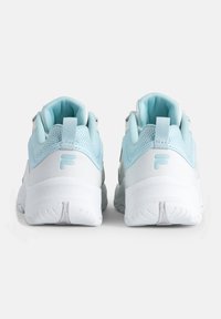 Une paire de baskets blanches et bleu clair vue de l'arrière avec une semelle épaisse et la lettre "F" sur la partie du talon.