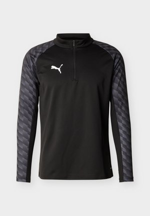 Μαύρο αθλητικό τοπ με μακριά μανίκια και φερμουάρ έως το στήθος, με γκρι μανίκια με σχέδια και λευκό λογότυπο Puma στο στήθος.