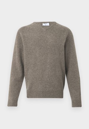 Brown knit sweater made of soft material, featuring a round neckline and ribbed cuffs and hem, with minimal branding on the tag.