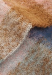 Wollstoff in einer Mischung aus Pastellfarben, einschließlich Pink, Braun und Blau, mit einer weichen, strukturierten und leicht fuzzy Oberfläche.