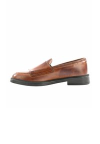 Scarpa in pelle marrone senza lacci con punta rotonda, dettagli cuciti e suola nera in gomma bassa. Superficie liscia con minimi accenti.