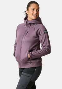 Paarse hoodie met een rits aan de voorkant, zijzakken en een logo patch op de mouw; gemaakt van gestructureerde, rekbare stof voor comfort.