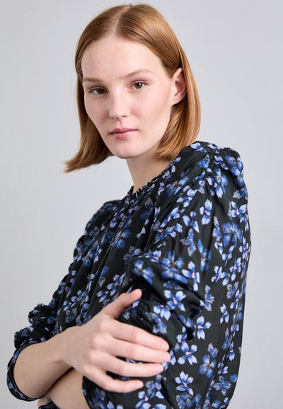 Schwarze Blumenshirt mit blauen und weißen Blumen, geraffter Textur an den Ärmeln, runder Ausschnitt und weichem Stoff.