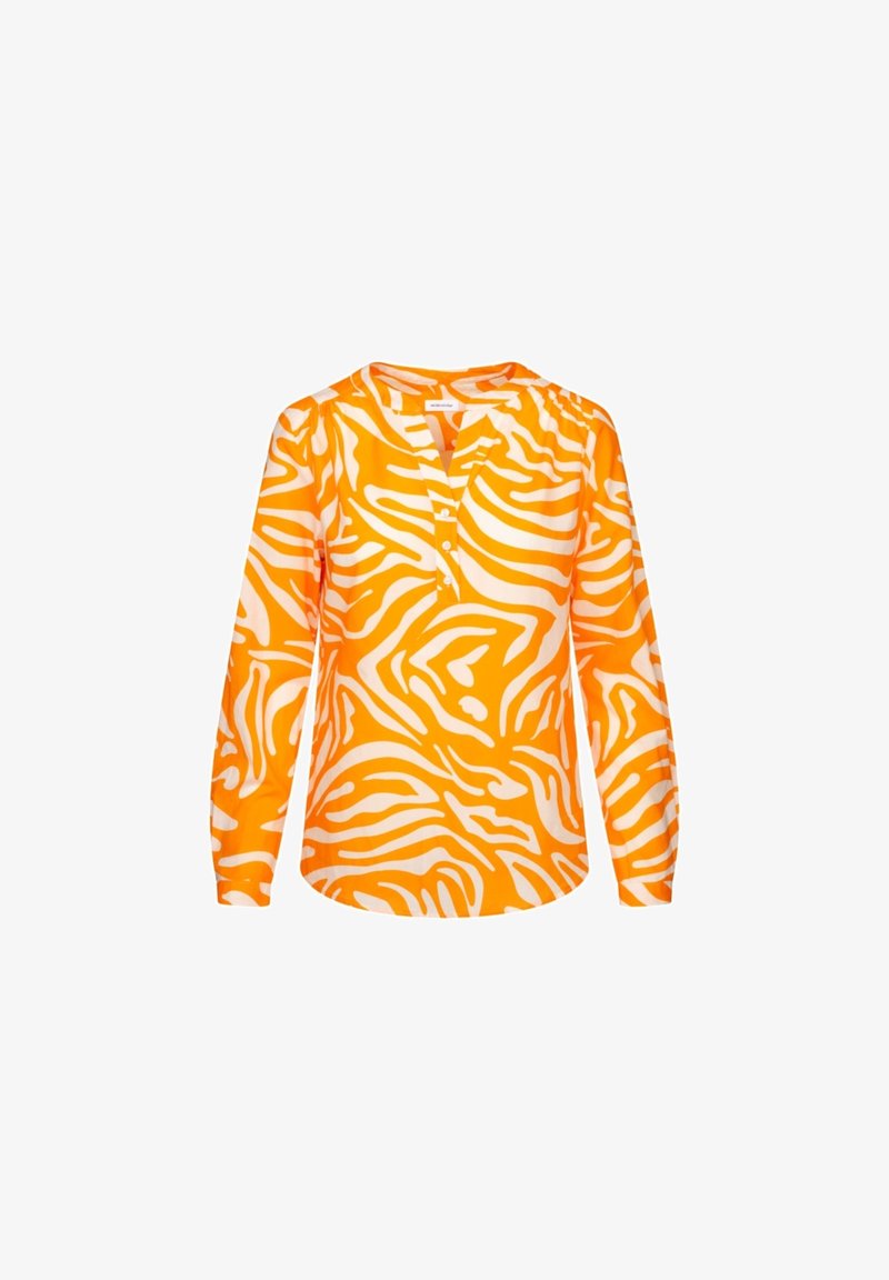 Blouse orange à manches longues avec des rayures blanches zébrées, un col sans col et une patte boutonnée sur fond blanc.