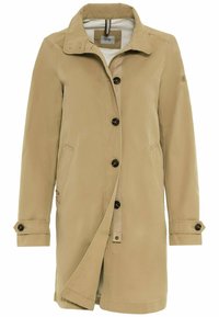 Beige trenchcoat vyrobený z hladké tkaniny, s klopovým límcem, černými knoflíky, bočními kapsami a nastavitelnými manžetami.