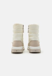 Vanntette vinterstøvler med kremfarget quiltet overdel, beige detaljer, robust gummisåle og bakglidelåser for enkel påkledning.