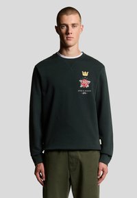 Dunkelgrüner Sweatshirt mit langen Ärmeln, Rundhalsausschnitt und gestickten Designs, darunter ein Kronen- und Rosenemblem auf der Brust.