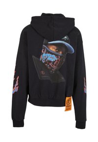 Sweat à capuche noir avec un visuel d'une personne portant une casquette bleue et un masque facial à motifs dans le dos, des motifs de flammes sur les manches, et une étiquette orange près de l'ourlet.