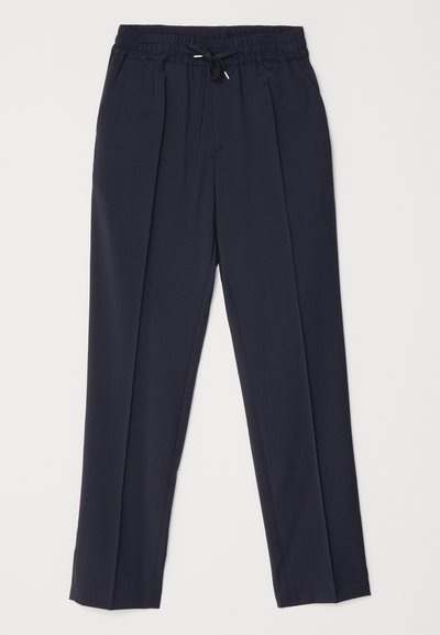 Mørkeblå bukser med elastisk linning og snoren. Har to frontfold og avsmalnende ben for en strukturert silhuett.