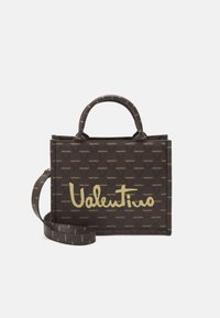 Brun handväska med guld "Valentino"-logotyp, med en strukturerad design, dubbla handtag och avtagbar axelrem. Mönstrad logodetalj över hela väskan.