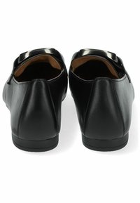 Ballerine in pelle nera con forma arrotondata, texture liscia e un accento lucido sul tallone. L'interno è foderato con materiale beige.