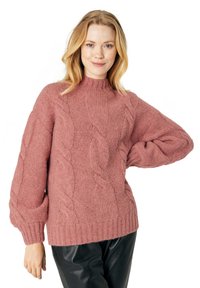 Maglione rosa a trecce con collo alto, maniche ampie e orlo a coste, realizzato in un materiale spesso e testurizzato.