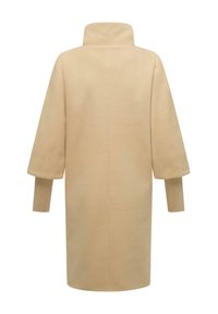 Béžový vlnený kabát s vysokým golierom, širokými rukávmi a rebrovanými manžetami; disponuje čistým, minimalistickým dizajnom bez viditeľných zapínaní alebo ozdôb.