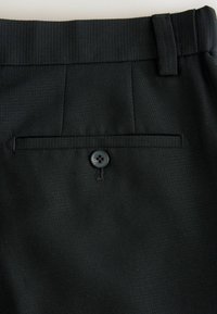 Pantaloni negri dintr-un material texturat, cu un buzunar pe spate cu clapetă, și un design cu talie plată.