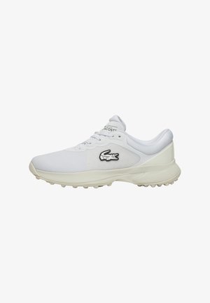 Chaussure de sport blanche avec tige en maille, semelle épaisse et semelle extérieure en caoutchouc pour l'adhérence. Présente un logo Lacoste noir sur le côté.