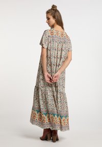 Blumiges Maxikleid aus leichtem Stoff, mit Rundhalsausschnitt, Schmetterlingsärmeln, gestuftem Design und lebhaft gemustertem Saum.