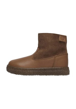 Botte cheville en cuir marron avec une tige en daim, bout arrondi et semelle en caoutchouc texturée. Dotée d'un patch de marque à l'arrière.