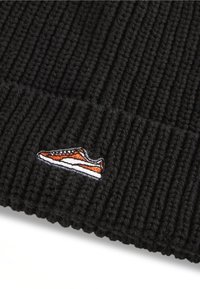 Black ribbed beanie made of soft knit material, featuring a small embroidered orange and white sneaker logo on the front.