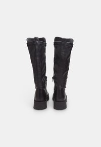 Black knee-high boots with a smooth leather finish, featuring side zippers and a thick sole for durability and support.
